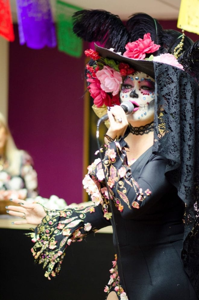 A woman in costume singing for Dia de los Muertos