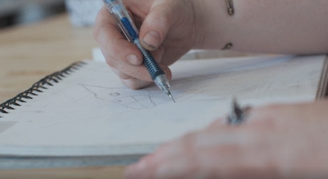 An artist works on a drawing