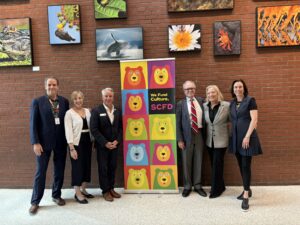 Executives of Tier I organizations stand with SCFD executive director Deborah Jordy by a colorful SCFD banner