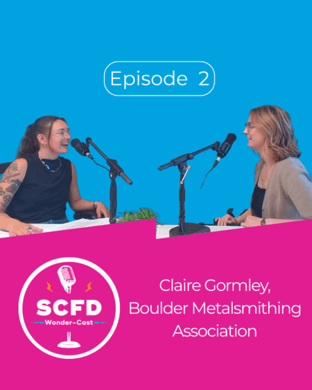 Graphic for Episode 2 of SCFD Wonder-Cast where Emma and Claire smile at each other in front of mics on a blue background with a pink title graphic below.