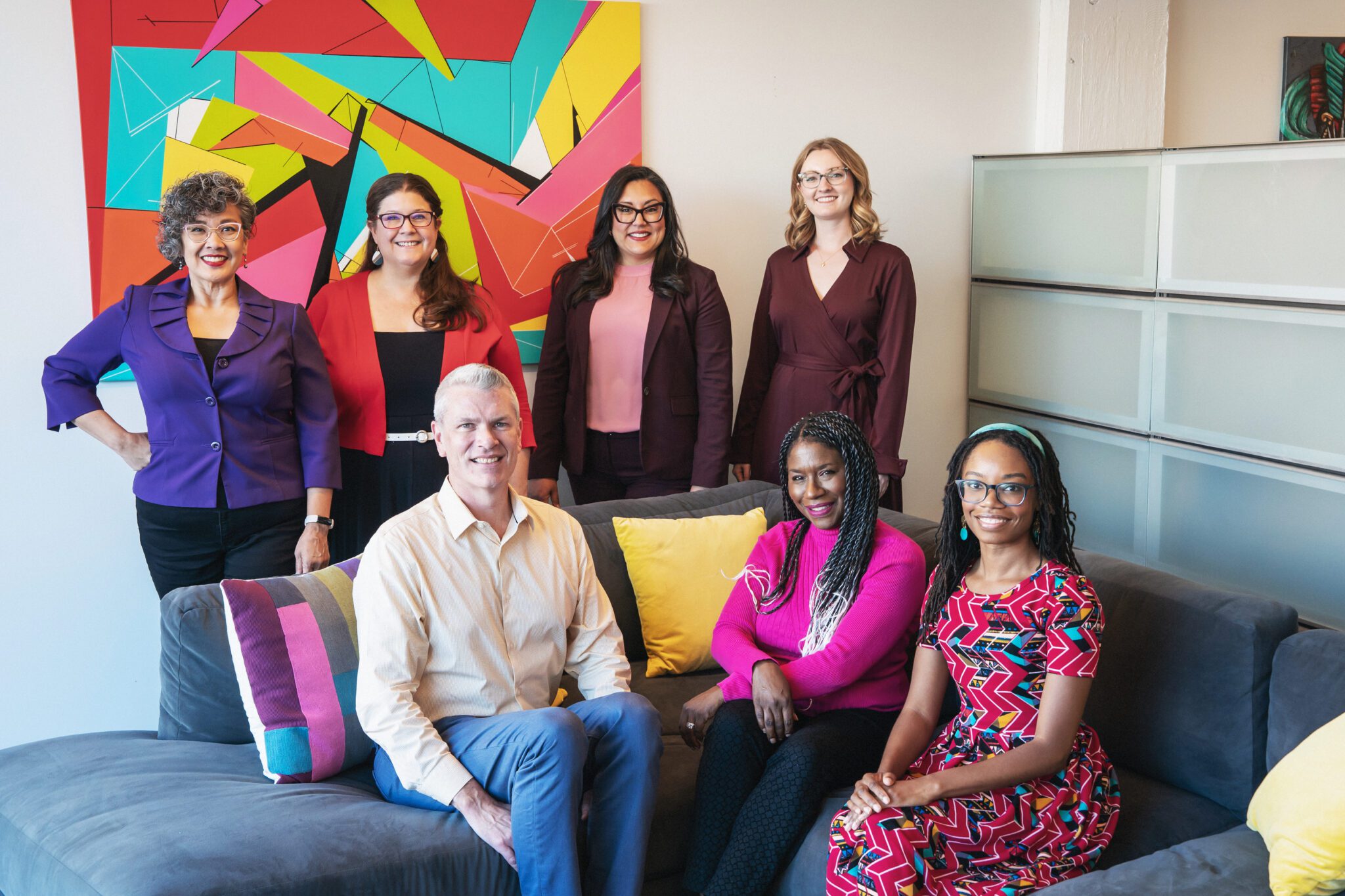 SCFD staff stand around and sit on a gray couch